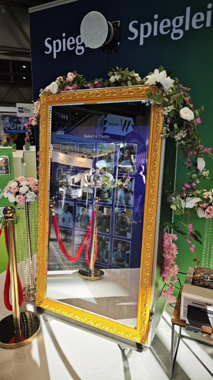 AI-Fotobox mit goldfarbenem Spiegelrahmen bei einer Messe